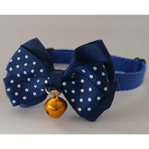 Dunkelblaues Katzenhalsband mit weißen Punkten, einer Schleife und einem kleinen goldenen Glöckchen.
