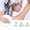 Frau wäscht ihre Haare mit einer Silikon-Kopfmassagebürste unter der Dusche, mit Schaum auf dem Haar.