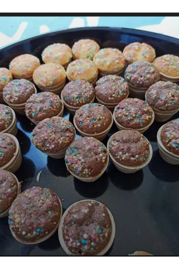 Mini-Waffelbecher-Muffins – Perfekte süße Häppchen für jeden Anlass! Kleine, bunte Mini-Muffins, gebacken in essbaren Waffelbechern, mit Schokoladen- und Vanilleteig, dekoriert mit bunten Zuckerperlen.