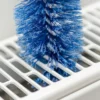 Nahaufnahme der Heizkörper-Reinigungsbürste im Einsatz – effektive Entfernung von Staub & Schmutz zwischen den Heizkörperlamellen.