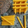 Handgerollte Wunschkerzen aus natürlichem Bienenwachs, gestapelt und lose auf Marmorplatte arrangiert