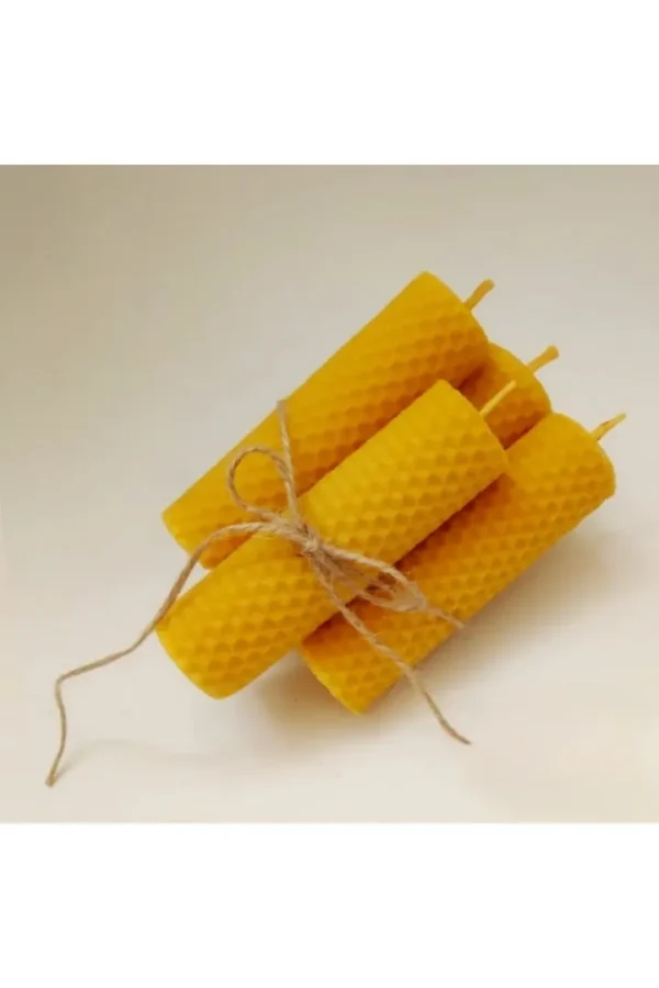 Vier handgerollte Bienenwachskerzen, mit Naturfaserband gebunden, auf hellem Hintergrund